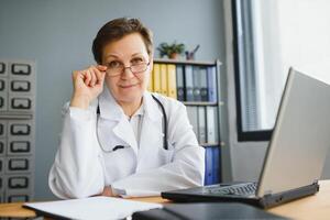 médico de meia idade feminino escrevendo prescrição foto