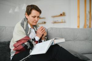 Senior mulher lendo livro às lar. foto