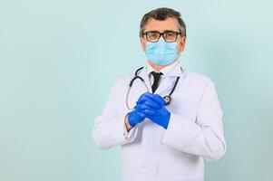 homem dentro médico luvas e protetora face mascarar contra azul fundo. foto