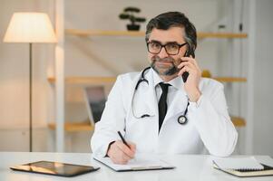 fechar-se do médico falando em a telefone dentro a escritório. foto