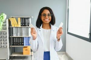 cuidados de saúde e médico conceito - africano médico com bolha pacotes do pílulas. foto