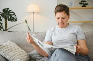 mulher lendo jornal às casa foto