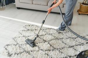 limpeza conceito. mulher limpeza tapete com vácuo limpador. foto