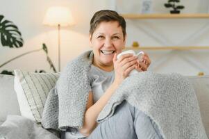 ótimo olhando meio envelhecido mulher tendo uma calma manhã e desfrutando dela café. foto