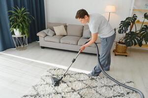 limpeza conceito. mulher limpeza tapete com vácuo limpador. foto