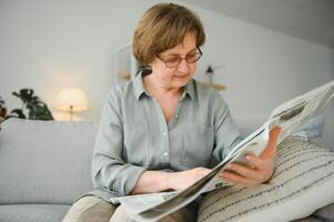 era e pessoas conceito - feliz Senior mulher lendo jornal às casa foto