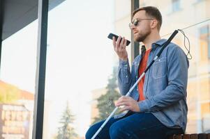 cego homem esperando para ônibus às uma ônibus estação foto