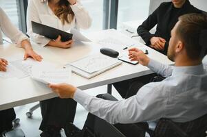 uma grupo do o negócio pessoas parceiros durante uma conjunto equipe encontro dentro a moderno escritório. trabalho em equipe conceito foto