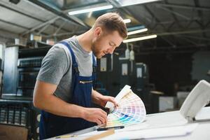 retrato do Produção linha trabalhador controlando fabricação processo do moderno embalagem industrial máquina dentro impressão fábrica foto