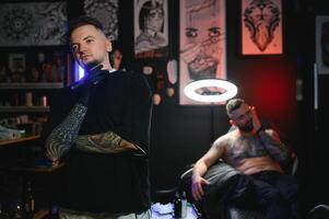 retrato do tatuagem artista em pé dentro salão foto