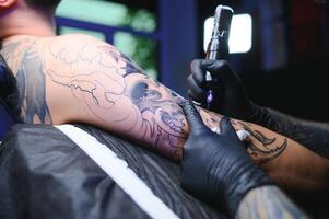 profissional tatuagem artista faz uma tatuagem foto