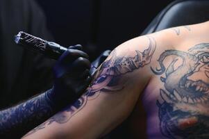 tatuagem artista mãos vestindo luvas e segurando uma tatuagem máquina foto