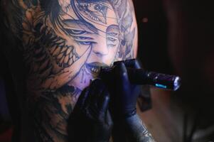 tiro do uma tatuagem artista mãos formando perfeito linhas em homem costas com tinta foto