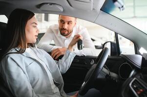 lindo jovem fêmea cliente cliente escolhendo Novo carro foto