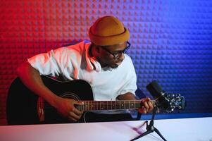 africano americano homem com guitarra dentro gravação estúdio foto
