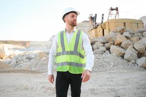 masculino trabalhador com escavadora dentro areia pedreira foto