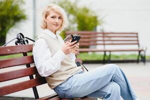 jovem lindo bonita menina caminhando ao longo a rua com Bolsa e copo do café. foto