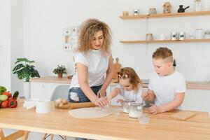 família Aprendendo Novo receita junto. feliz mãe e crianças mistura ingredientes para caseiro bolo, torta ou bolacha massa dentro a cozinha. foto