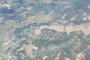 aéreo Visão do agrícola campo, rio e nuvens visto através avião janela foto