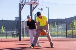 uma pai e filha jogando basquetebol dentro a parque foto