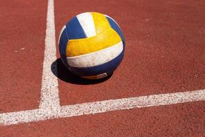 voleibol. azul com amarelo cor bola em a Parque infantil. voleibol cobrir, vermelho. bola jogos foto