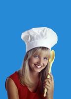 jovem sorridente Loiras chefe de cozinha com dela colorida colher posando em neutro fundo foto
