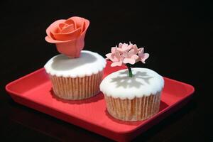 bolos de copo com açúcar flor decoração em vermelho bandeja foto