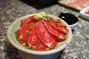 fechar acima carne tataki, fracamente fatiado e queimado japonês carne servido com ponzu, infundido vinagre soja molho com citrino e gengibre foto