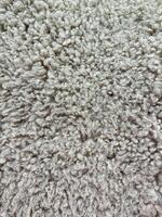 detalhado macro tiro do denso, encaracolado cinzento lã textura com natural lã padrões para interior Projeto e têxteis. foto