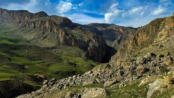 montanha panorama com verde vales, áspero falésias debaixo azul céu com nuvens. para publicidade bandeira ou postar cartão do ao ar livre aventura e viagem temas. foto