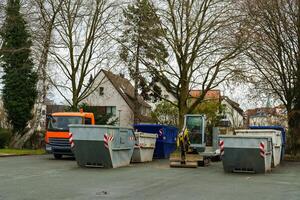 containers para construção desperdício e construção equipamento dentro a estacionamento muitos foto