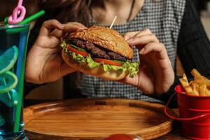 mulher desfrutando Hamburger com palito de dente foto