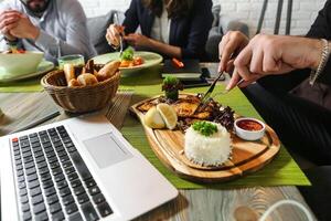 grupo do pessoas desfrutando uma refeição juntos às uma mesa foto