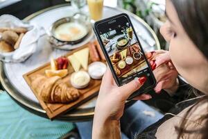 mulher fotografando Comida em telefone foto