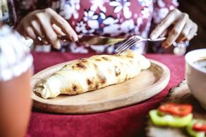 mulher comendo prato do Comida com garfo e faca foto