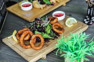 mesa adornado com pratos do Comida coberto dentro crocantes cebola argolas foto