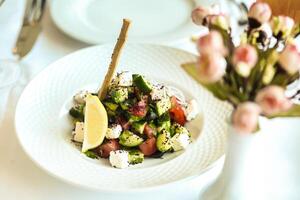 saudável salada com flor vaso em branco prato foto