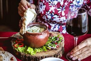 mulher sentado às mesa com prato do Comida e vidro do vinho foto