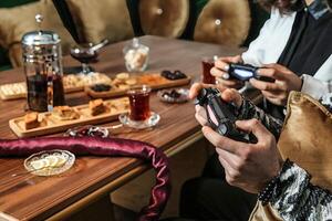 homem sentado às mesa segurando jogos controlador foto