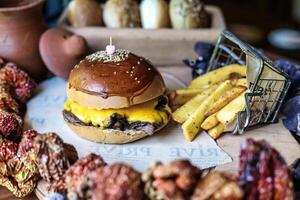 Hamburguer de queijo e fritas colocada em mesa foto