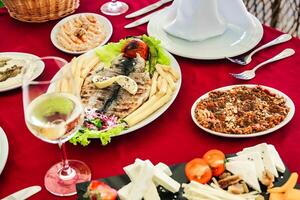 elegante mesa conjunto com travessas do Comida e óculos do vinho foto