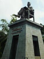 surakarta, central Java, Indonésia abril 11, 2024. a estátua do Sr soekarno sentado enquanto lendo uma livro, estátua do a primeiro Presidente do a republik Indonésia às manahan estádio. foto