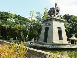 surakarta, central Java, Indonésia abril 11, 2024. a estátua do Sr soekarno sentado enquanto lendo uma livro, estátua do a primeiro Presidente do a republik Indonésia às manahan estádio. foto