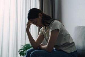 infeliz solitário depressivo mulher é sentado em a sofá e olhando baixa foto