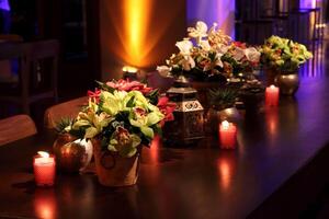 sofisticado festa decoração com velas, flores, mesas e especializado iluminação foto