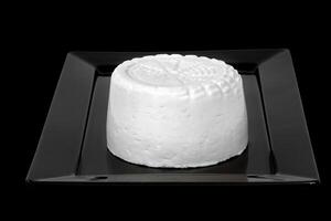fresco cabra leite queijo em uma Preto prato foto