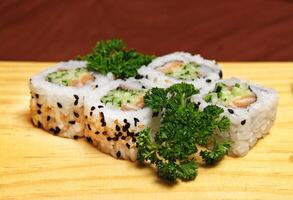 tradicional uramaki, japonês delicadeza com nori, sésamo, arroz vinagre, kani kama e japonês pepino foto