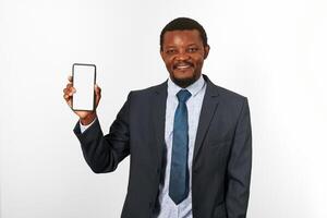 homem negro afro-americano sorridente em terno de negócios com maquete de smartphone na mão, fundo branco foto