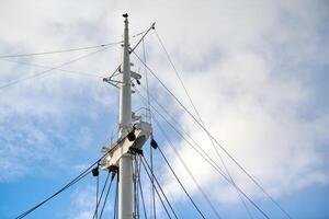 mastro de vela do navio no fundo do céu azul nublado foto