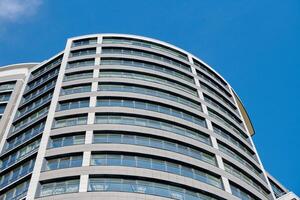 edifício de alto negócio de arranha-céu de escritório no fundo do céu azul, olhando para o edifício moderno de vidro foto